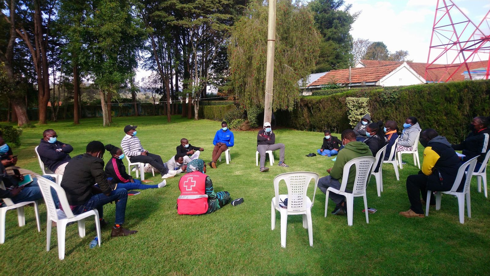 Psychological First Aid group session, participants seated in a circle outdoors
