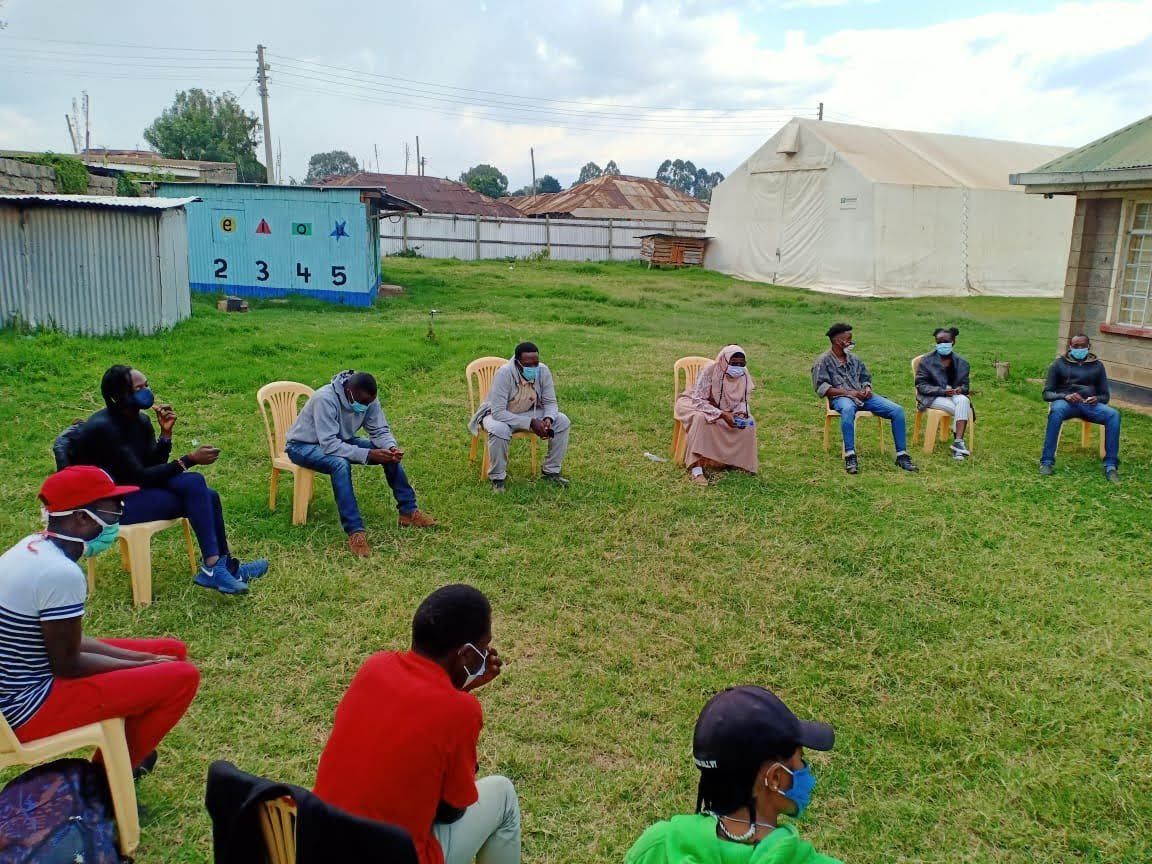 Psychological First Aid group session, small seated group outdoors